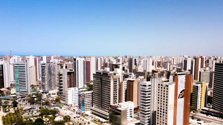 Aerial cityscape of Fortaleza, Brazil, featuring modern skyscrapers under a clear blue sky.