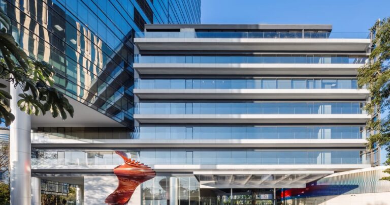 Fachada de edifício comercial moderno espelhado representando lajes corporativas