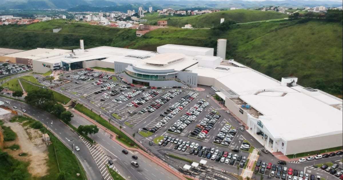 Fachada externa de um shopping center com design moderno, representando a gestão de ativos imobiliários comerciais.