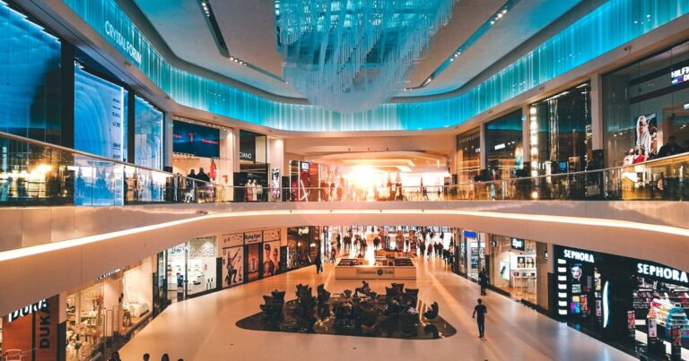 Corredor de shopping center moderno e iluminado representando a venda de ativos imobiliários pelo fundo VISC11.