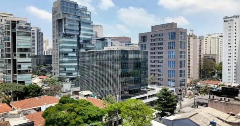Fachada de um edifício comercial moderno de vidro em um dia ensolarado.