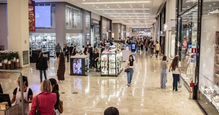 Corredor de shopping center com lojas, representando a carteira de shoppings dos fundos imobiliários.