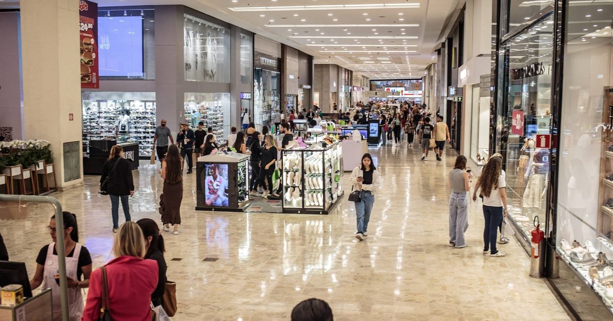 Corredor de shopping center com lojas, representando a carteira de shoppings dos fundos imobiliários.
